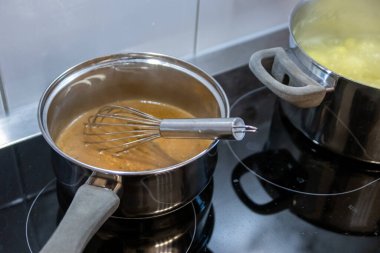 Mutfakta elektrikli ocakta çorba pişirmek.