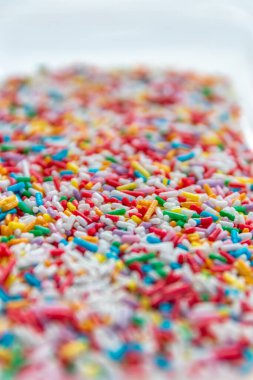 Lezzetli süsleme olarak bir sürü renkli süsleme veya doğum günü pastası üzerine tatlı şeker serpme şeker dişleri ve çocuklar için sağlıksız atıştırma donut ve gökkuşağı kekleri gibi lezzetli şekerlemeler.