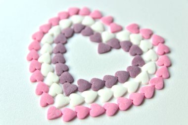 Tatlı pembe sevgililer günü şekerleri ve pembe, mor ve beyaz gösterilerle süslenmiş süsler. Seni kız arkadaşına ve değerli elmasları ve kırmızı kalpleri olan değerli insanlara özel bir hediye olarak seviyorum.