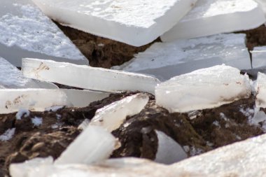 Aralık ve Ocak aylarında, soğuk kış mevsiminde donmuş su ve kış ikliminde manzaralı bir nehrin üzerinde kalın buzla kaplı bir buzulun çatlamış buzunu gösteren kırık bir buz tabakası.