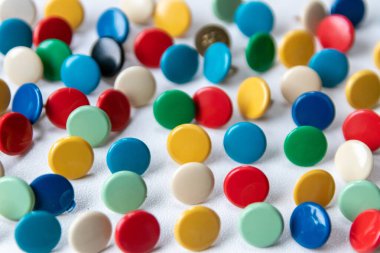 İş broşları ve okul organizasyonu ekipmanları için tasarım koleksiyonu olarak sarı, yeşil, mavi, kırmızı ve beyaz daireler halinde metal raptiyeler sağlayan çok renkli ofis raptiyeleri