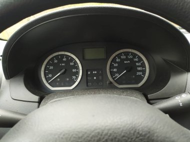 Otomobil göstergelerinde yakın çekim görüntüsü, hız ve hız göstergesi, takometre, takometre ve motorlu spor arabalardaki güvenli hareketlilik göstergelerine sahip araç kokpitinde ölçüm araçlarıyla birlikte.