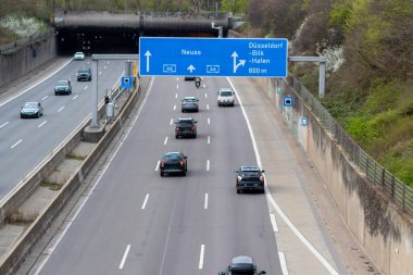 Düsseldorf 'taki boş Alman otobanı mavi sokak işaretleri ve trafiği olmayan beyaz oklarla, Alman şehirlerinde serbest otoyol olarak Corona zamanlarında trafiğin yoğun olduğu saatlerde çoklu şerit karayolunu gösteriyor.