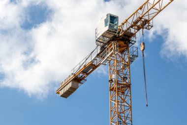 Bulutlu gökyüzü arka planında bir inşaat alanında vinç