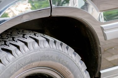 Şehir içi toprak yollarda ya da arazi araçlarının lastiklerinde askeri tasarım ve dört teker çekişli derin profilli arazi maceraları yüksek performanslı araba tekerlekleri tozu gösteriyor.