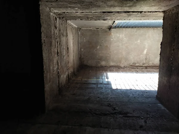 Dark ventilation shaft with sunlight through a metal grid shows concrete exchanger airway for basement and big facilities to get fresh air and ventilated pipe work for industry and architecture