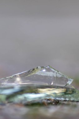 Keskin bıçaklarla yere serilmiş kırık bir cam şişenin keskin parçaları vandalizmden ve kırılgan şişeyi gösteren sarhoş insanlardan ve atıkları geri dönüşüm silahı olarak ezilmiş içeceklerden tehlikelidir.