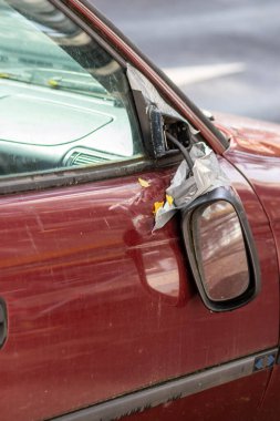 Araba kazası, vandalizm yaralanması ve kaçma sonucu sigorta kaybı gibi yıkık bir arabada asılı duran kırık bir yan ayna, şehirlerde tehlikeli trafik ve güvenlik sigortasına ihtiyaç olduğunu gösteriyor.