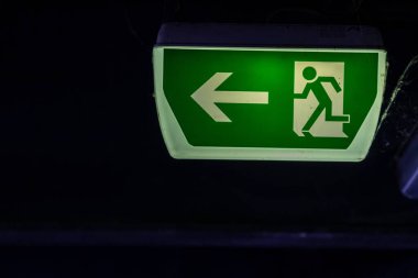 Yeşil çıkış işaretinde koşan kişi ve Green Arrow 'un belirttiğine göre park yerinde kurtarma ve tahliye için işaretler var.