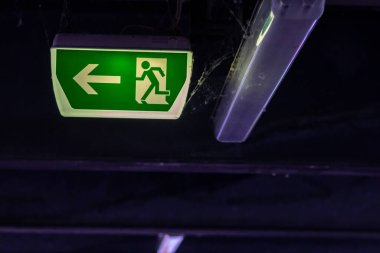 Yeşil çıkış işaretinde koşan kişi ve Green Arrow 'un belirttiğine göre park yerinde kurtarma ve tahliye için işaretler var.