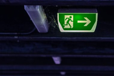 Yeşil çıkış işaretinde koşan kişi ve Green Arrow 'un belirttiğine göre park yerinde kurtarma ve tahliye için işaretler var.