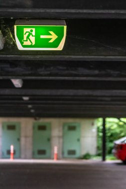 Yeşil çıkış işaretinde koşan kişi ve Green Arrow 'un belirttiğine göre park yerinde kurtarma ve tahliye için işaretler var.