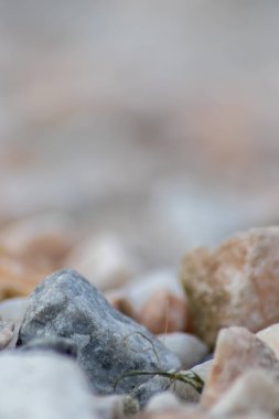 Ham kaya ve mineraller doğal taşlardır. Sert bir sahil veya kayalık plajda ezilmiş ve pürüzlü malzemelerle doğal mineral arkaplan olarak harmonik pastel renklerde külçeler ve kumtaşları gösterirler.