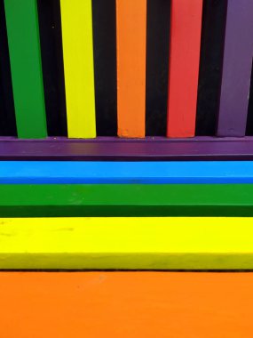 Çeşitlilik ve çeşitliliğin sembolü olarak farklı parlak renklere sahip renkli bank ve hoşgörü için gurur konsepti ve parklardaki ahşap mobilyaların mutlu yaşam tarzına sahip güzel bahçe dekorasyon koltuğu.