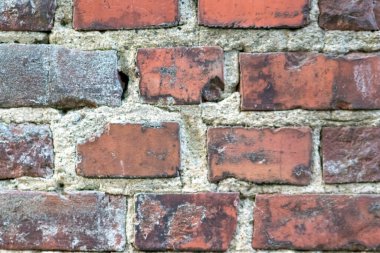 Kale duvarı gibi pürüzlü taşlarla kaplı büyük bir duvar, farklı tuğlalar, doğal arka plan ve kayalık antik zamanların duvarı, granit mineraller için eski dokular olarak taş gibi katı tuğlalar gösteriyor.