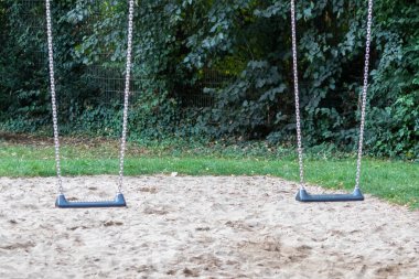 Parkın yanındaki çocuk parkında boş salıncaklar