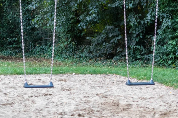Parkın yanındaki çocuk parkında boş salıncaklar