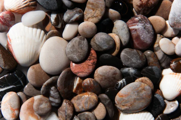 Background from multi-colored stones. Texture of sea stones. Red and blue pebbles. Stone beach. Minerals. Colorful stone. Semiprecious stones. Stereoscopic Cobblestone.