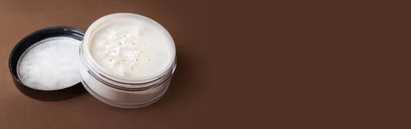 Skin matting powder on a brown background. White powder.