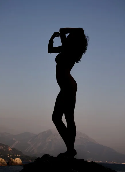Силует сексуальної дівчини на фоні моря і гір — стокове фото