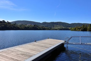 Gölün kıyısındaki iskele manzarası. Rahatlamak ve su sporları yapmak için ideal bir yer. Duvar, iskele, iskele..