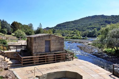 Mino nehrinin kıyısındaki dış termal banyo devresindeki eski bir su değirmeninin görüntüsü. Boş zaman ve sağlık merkezi.
