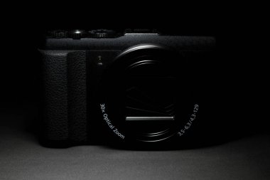 Bir kompakt noktayı kapat ve koyu arkaplan ve yumuşak ışıklandırmalı stil kamera çek. Kamera üreticileri, fotoğrafçılık pazarı