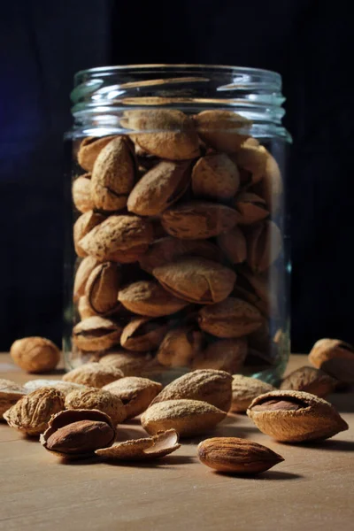 glass jar full of natural almonds with peel. Dried fruits from organic crops