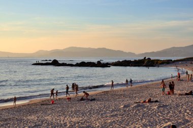 Vigo, Pontevedra, İspanya Ağustos 2020 Bir yaz günü gün batımında Samil sahilinde yürüyen insanlar