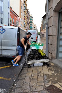 Alicante, İspanya Eylül 2020 'de maskeli bir tüccar marketteki tezgahına taze deniz ürünleri taşıyor.