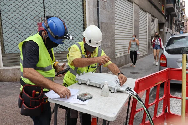 Elche, İspanya Eylül 2020 telekomünikasyon teknisyenleri yeraltı caddesinde fiber optik döşeme kuruyor.