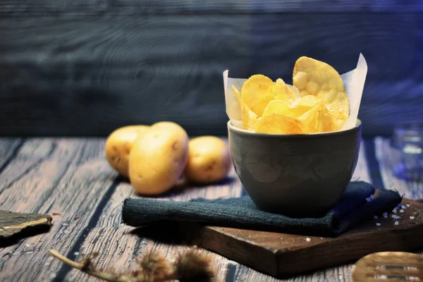 Hayat boyu patates cipsi. Aperatifler ve atıştırmalıklar. Gıda sektörü, aşçılık fotoğrafçılığı kırsal ve karanlık stil