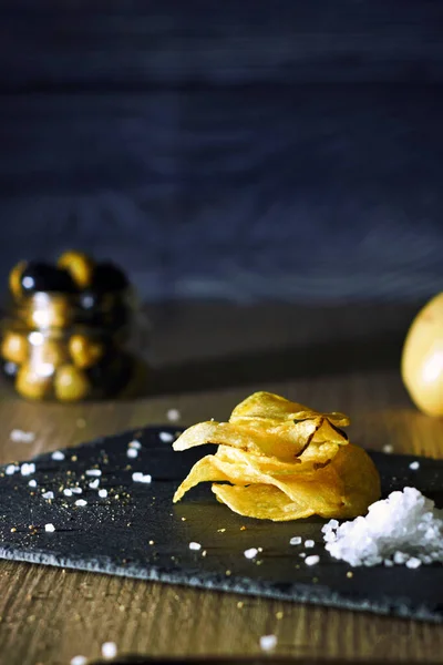 Patates cipsi dolu bir hayat. Aperatifler ve atıştırmalıklar. Gıda sektörü, aşçılık fotoğrafçılığı kırsal ve karanlık stil