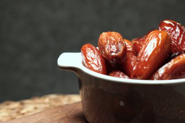 Bir kâse dolusu yakın çekimli hurma. Kırsal yemek fotoğrafçılığı, gastronomik ve aşçılık. Kurumuş meyve