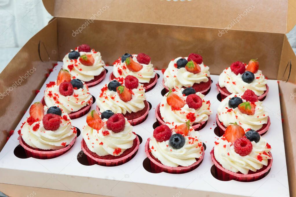 Delicious cupcakes with fresh berries( raspberries, strawberries,  blueberry) in a box.