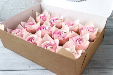 Pasta kutusunda pembe ve beyaz kremalı ev yapımı kekler. Kutuda pasta teslimatı..