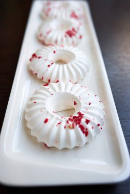 Kırmızı hamur kırıntıları serpiştirilmiş beyaz pastalar. Yakın plan. Seçici odak