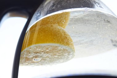 Yarım sarı limon, cam bir su ısıtıcısında kaynatılır.