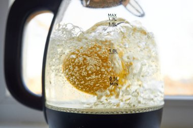 Yarım sarı limon, cam bir su ısıtıcısında kaynatılır.