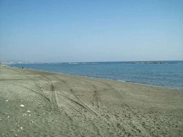 Spiaggia vuota della costa mediterranea a Limassol, Cipro, in inverno, a febbraio. Attraversamento tracce di pneumatici nella sabbia — Foto Stock