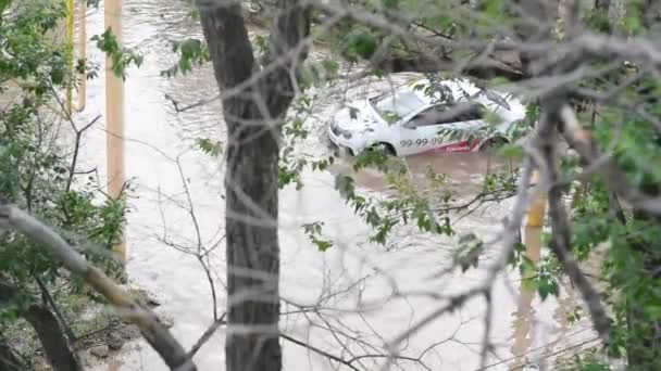 Astrakhan, Russie - 31.05.2021 : Une voiture nage à travers une flaque géante formée dans une rue de la ville après une longue tempête de pluie — Video
