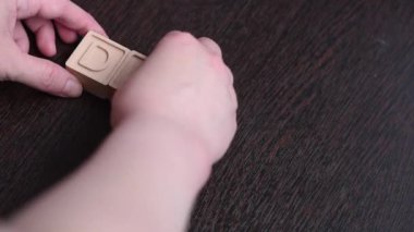 Dişi bir el tahta küplerle kelime oyunu yapar. Kavram