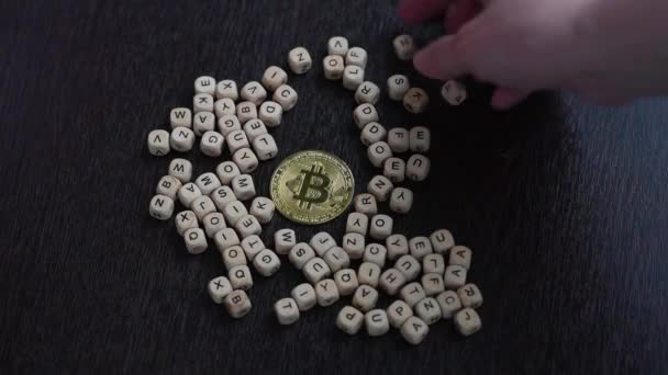 Kadın eli, altın bitcoin 'i ahşap harflerle çevreler. Kavram — Stok video