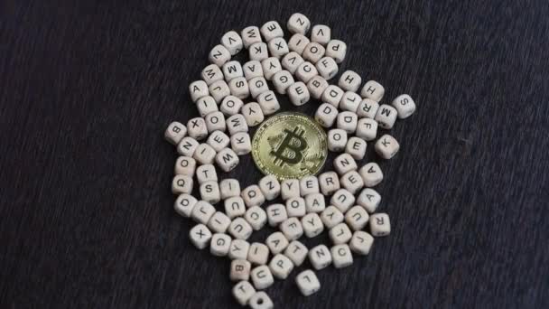 Tangan wanita mengelilingi bitcoin emas dengan huruf kayu. Konsep — Stok Video
