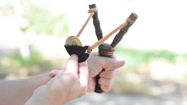 Golden bitcoin is fired by a wooden slingshot — Stock Video