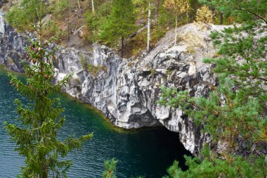 Ruskeala Dağ Parkı 'ndaki eski bir mermer ocağı yeraltı suyuyla dolu ve sonbahar ormanıyla çevrili.