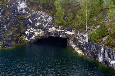Ruskeala Dağ Parkı 'ndaki eski bir mermer ocağı yeraltı suyuyla dolu ve sonbahar ormanıyla çevrili.