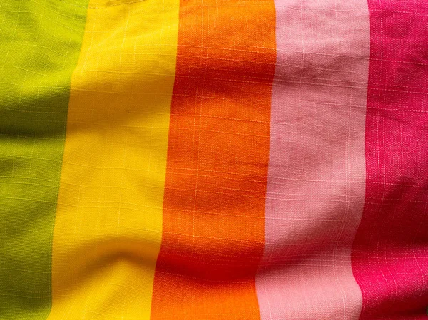 Kırmızı, pembe, sarı, turuncu ve yeşil çizgili parlak renkli kumaş.