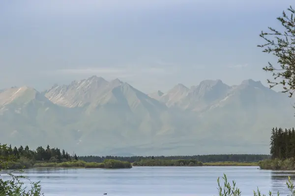 Floden mot bergen i ett töcken — Stockfoto