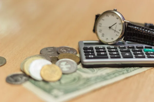 Na het werken aan een tafel klok, dollar munten. — Stockfoto